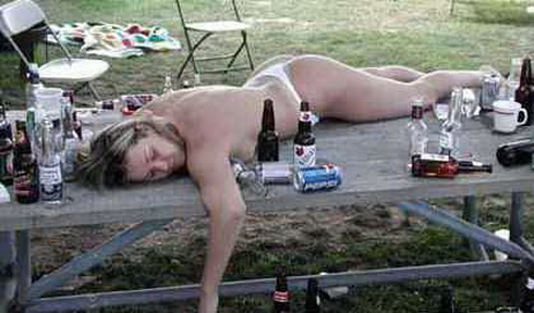 отдохнула... голая женщина спит на столе среди пустых бутылок. порноприкол